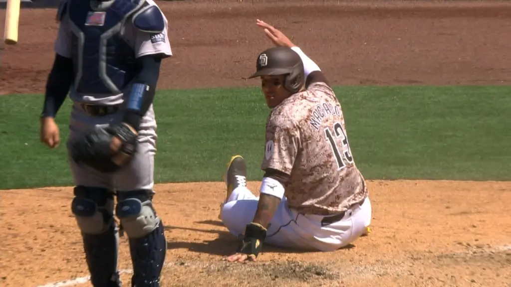Manny Machado se desliza en el plato a salvo durante el partido ante los Yankees de Nueva York este domingo.