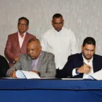 Miguel Medina del Grupo Panorama firma acuerdo con Juan Núñez de la Federación Dominicana de Béisbol.