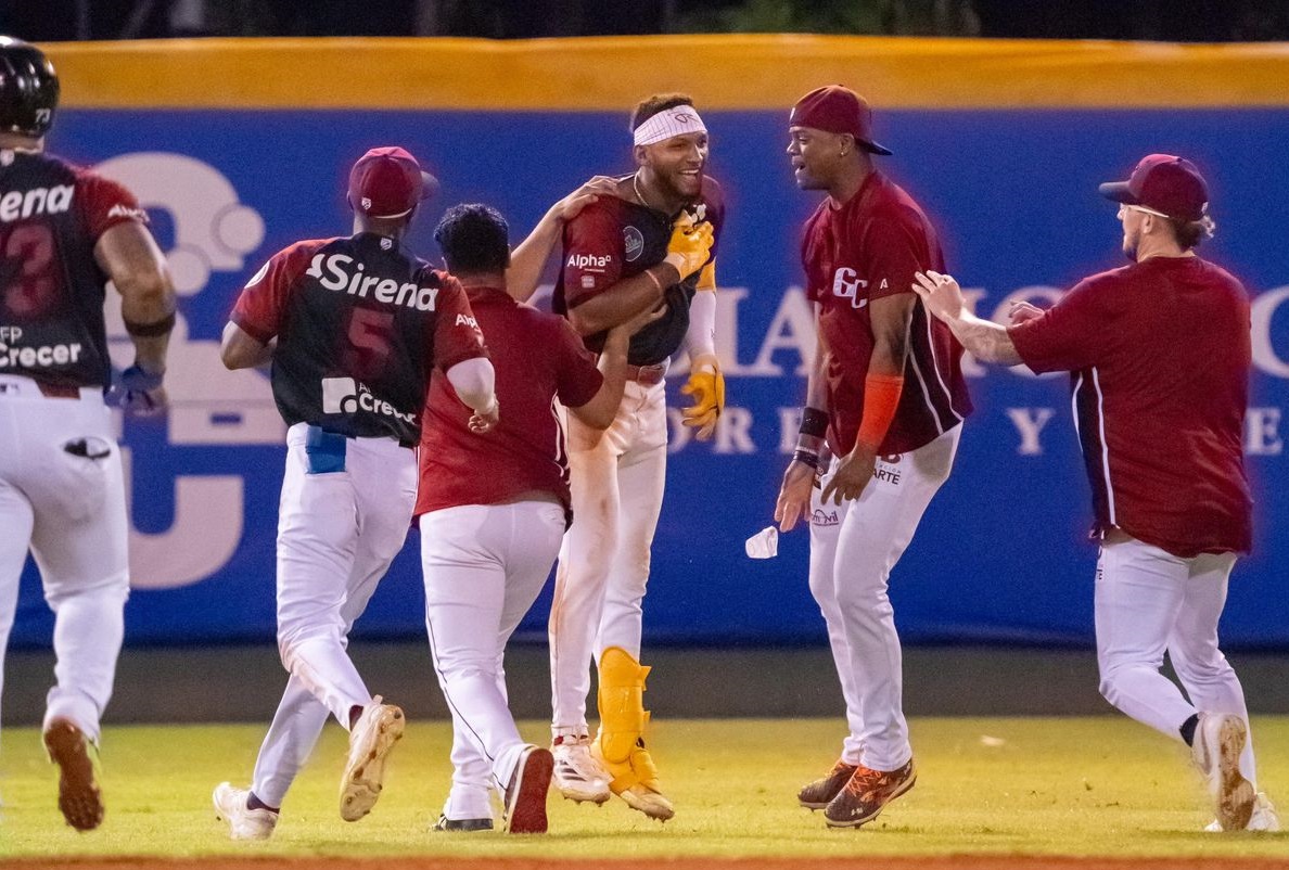 Jugadores de los gigantes felicitan a Johan Rojas por lograr el batazo de la victoria sobre Estrellas.