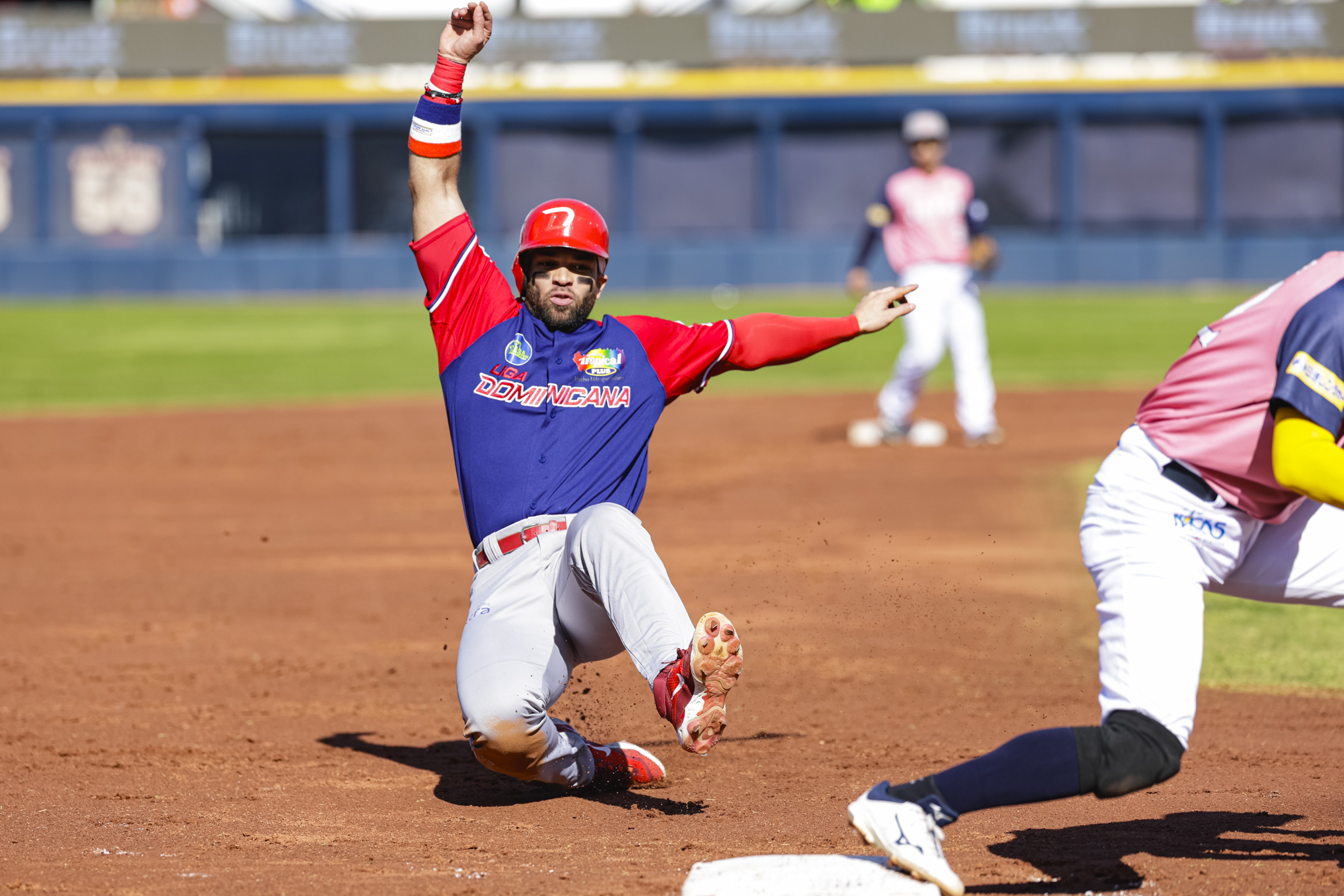 El dominicano José Marmolejos llega a tercera base ante Japan Breeze en el juego de este sábado que ganó RD 12-1.