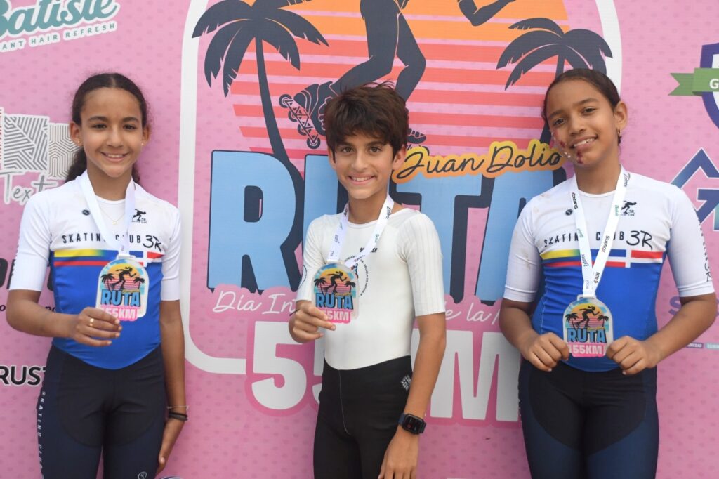 Mia Punnose, Matías Grateraux y Mia Benito, menores de 10 años, con su medalla por completar el recorrido en patines de 55 kilómetros, organizado por Skate Media por el Día Internacional de la Mujer.