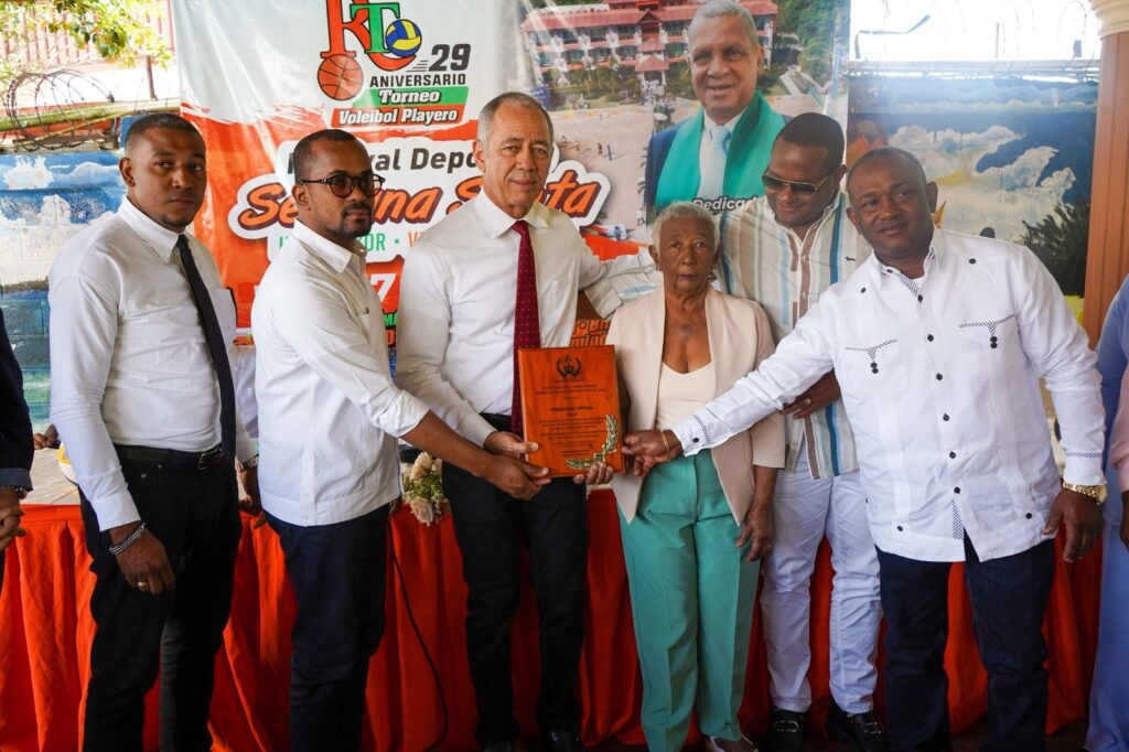 El torneo de dominó del Festival Deportivo Hato Mayor/Vicentillo 2025, está dedicado In Memoriam al Prebisterio Ortega (Onguí). Sus familiares reciben una placa de reconocimiento por la dedicatoria, que entrega Rubén Darío Cruz Ubiera, (tercero desde la izquierda), presidente del Comité Organizador. Figuran desde la izquierda Ricard Monegro, de la Gobernación de Hato Mayor y los familiares del homenajeado José Manuel Ortega, la señora Ana Celia Calderón, Juan Ortega y Johnny Ortega.