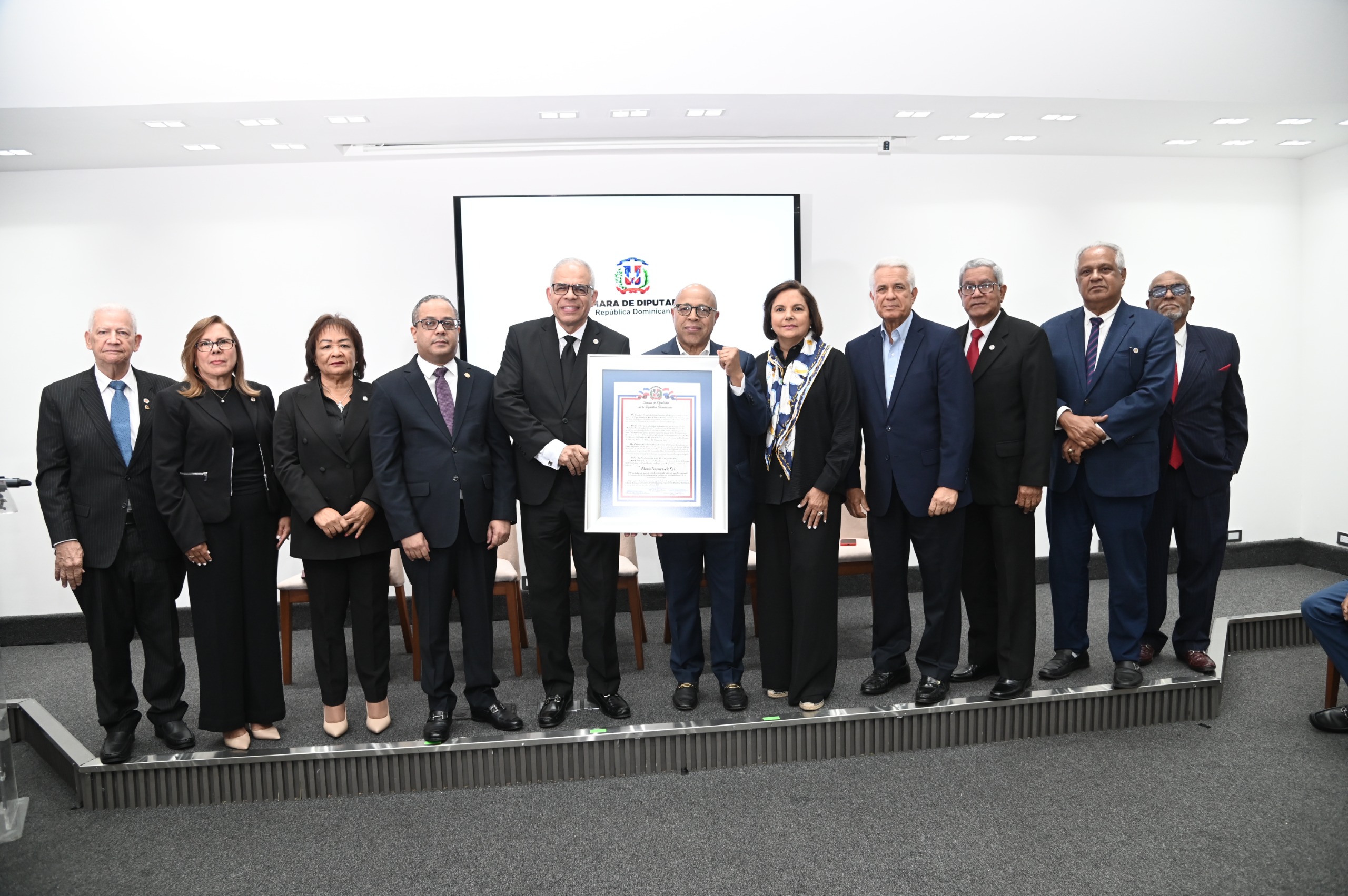 Carlos Manuel Estrella, periodista y presidente del Instituto Ateneo Amantes de la Luz, al centro, recibe su reconocimiento.