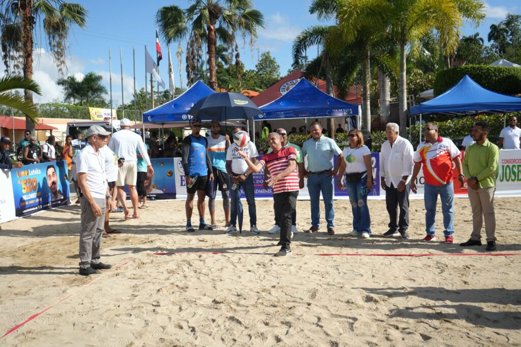 El periodista Leo Corporán realiza el saque de honor para dejar inaugurado el torneo 29 de voleibol playero, Semana Santa Hato Mayor/Vicentillo Semana Santa 2025. Fue recibido por Prisila Rivera, ex capitana de la Reina del Caribe