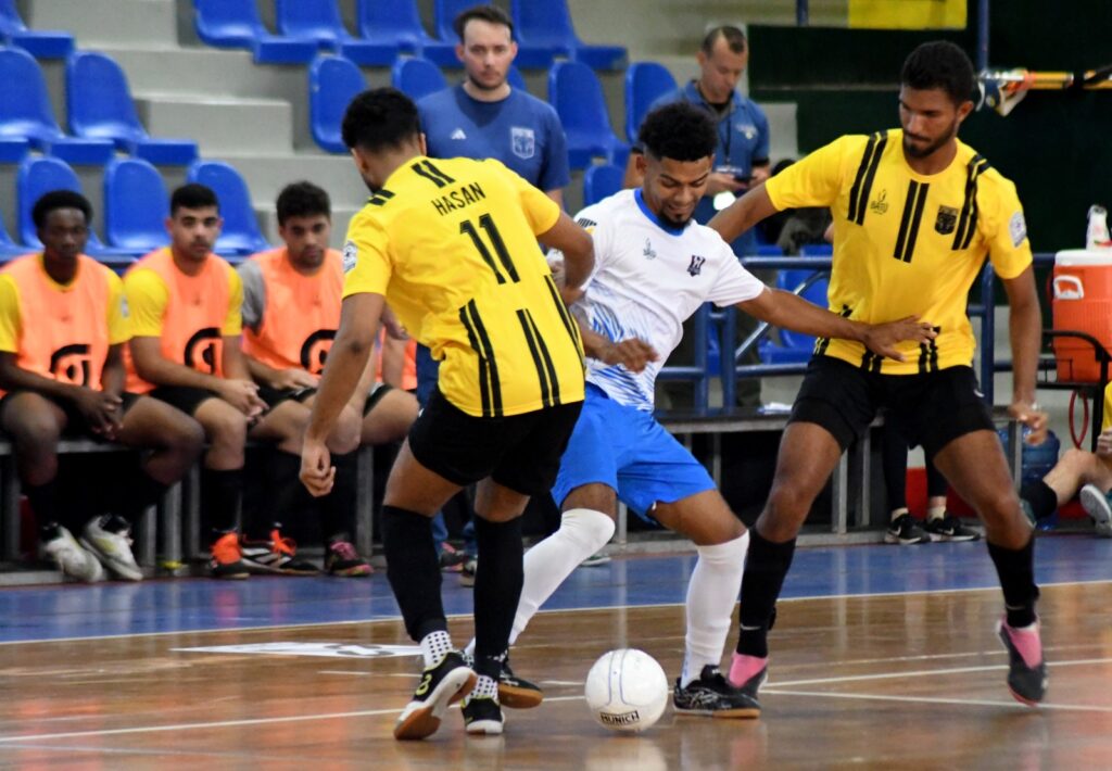 Damelbys García, del equipo SF Niupi Santiago, se cuela en una ofensiva entre los jugadores del Sporting SD, Omar Hasan y Diego Pérez