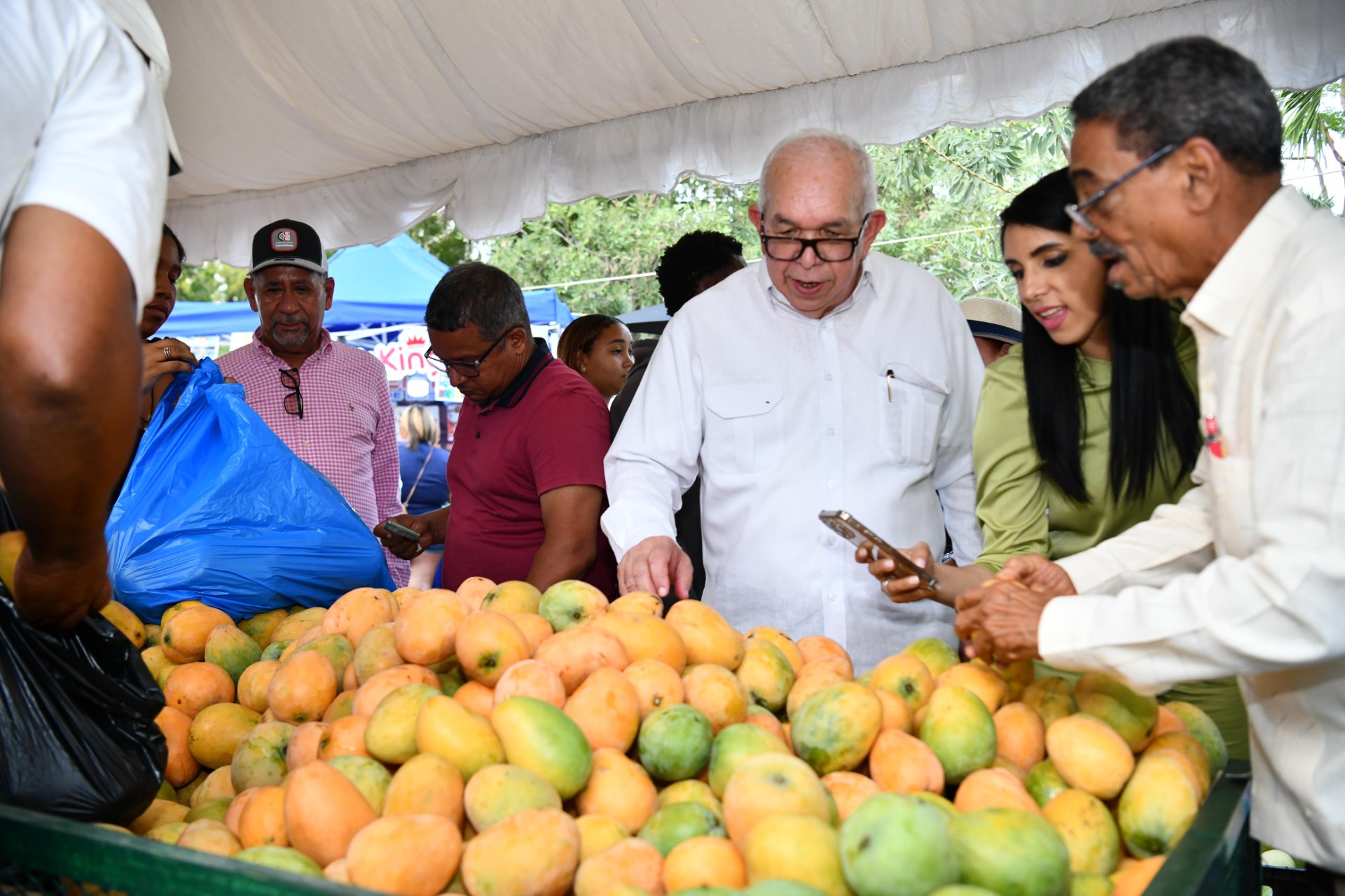 Fernando Durán y otros funcionarios del Bagrícola observan las variedades de mango expuestas en la feria / Fuente externa