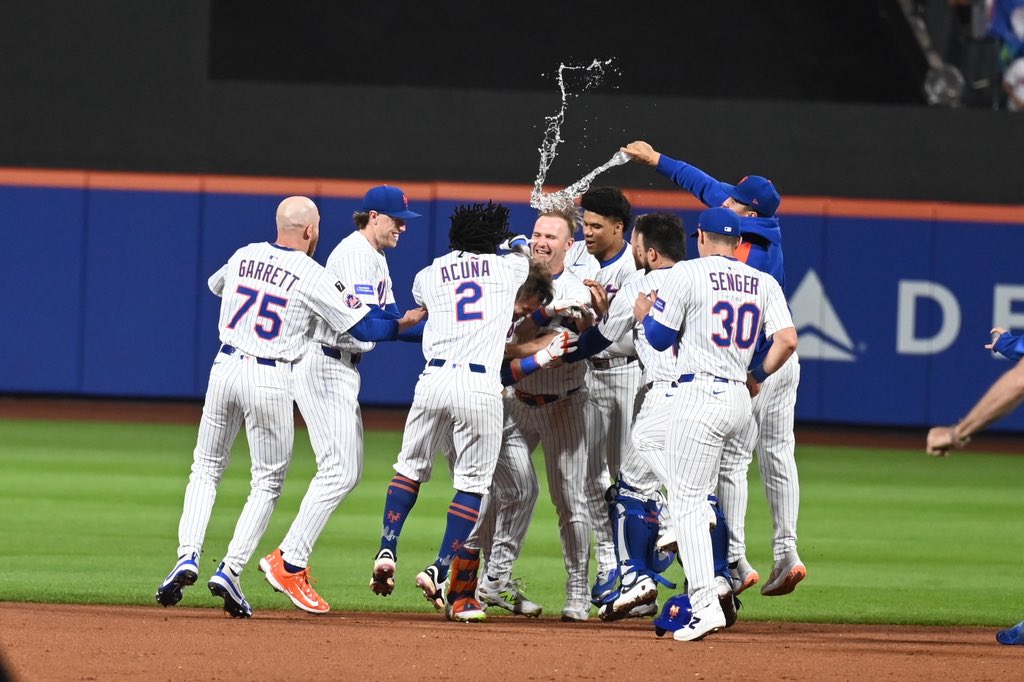 Jugadores de los Mets celebran la victoria en entradas extras sobre los Nacionales de Washington.