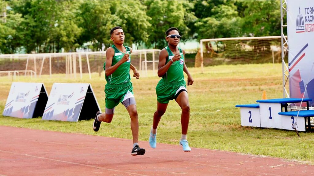 Dos alumnos se disputan el primer lugar en una de las eliminatorias del Torneo Nacional de Atletismo Escolar INEFI, efectuado en el complejo deportivo Pedro Julio Nolasco, de La Romana.