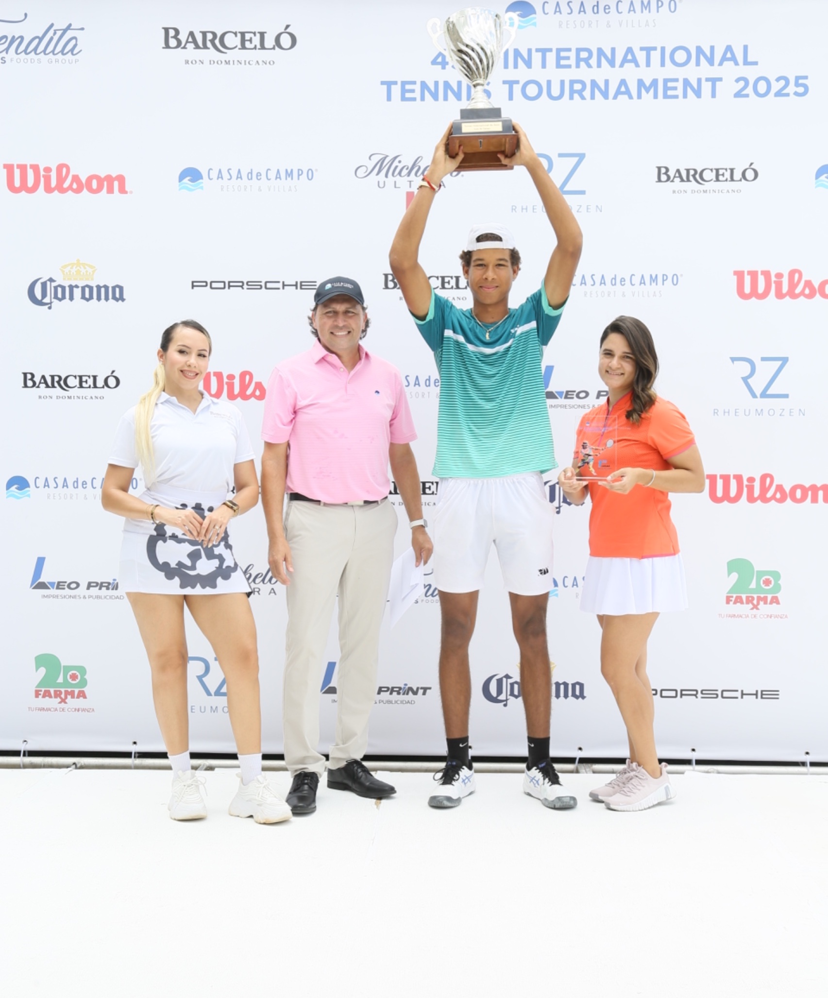El vegano Enmanuel Muñoz Veras levanta la copa de campeón de la 45 versión del Torneo Internacional de Tenis de Casa de Campo 2025. Le acompaña, Matias Territoriale, director del Racquet Center.