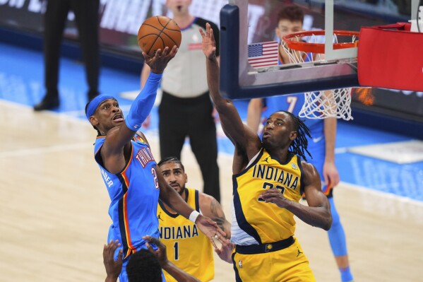 Shai Gilgeous-Alexander va hacia el canasto ante la defensa cerrada de lso Pacers.