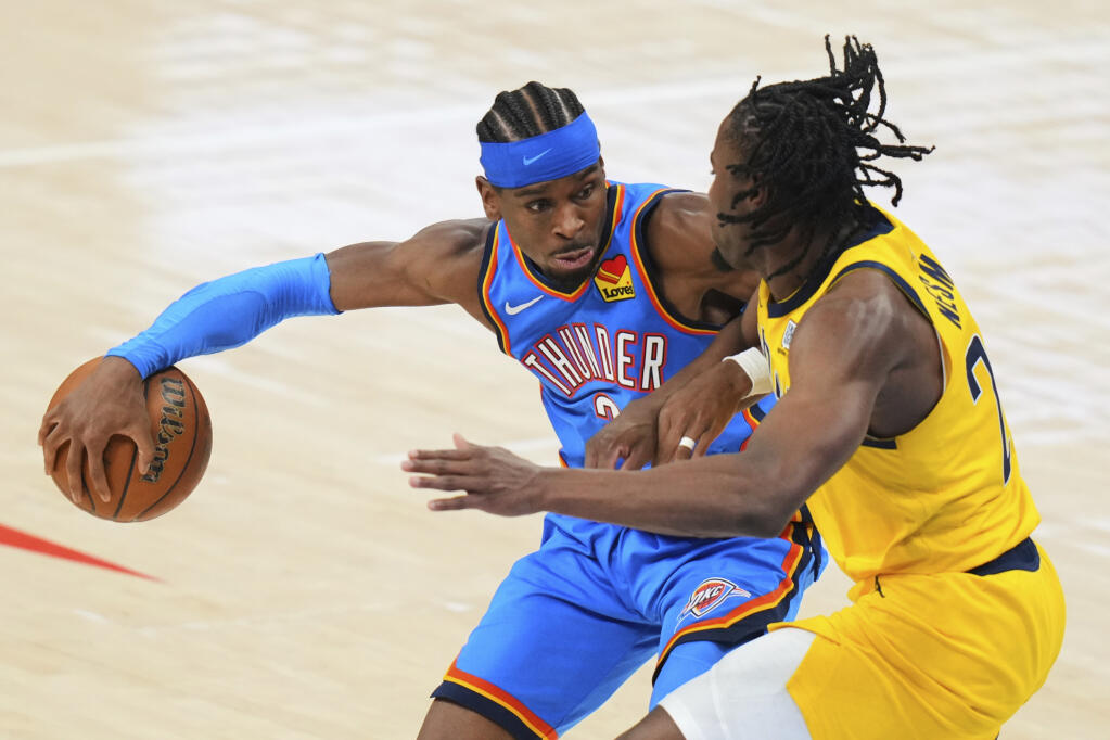 El defensa de Oklahoma City Thunder, Shai Gilgeous-Alexander (2), es defendido por el jugador de Indiana Pacers, el delantero Aaron Nesmith. (AP Photo/Kyle Phillips)