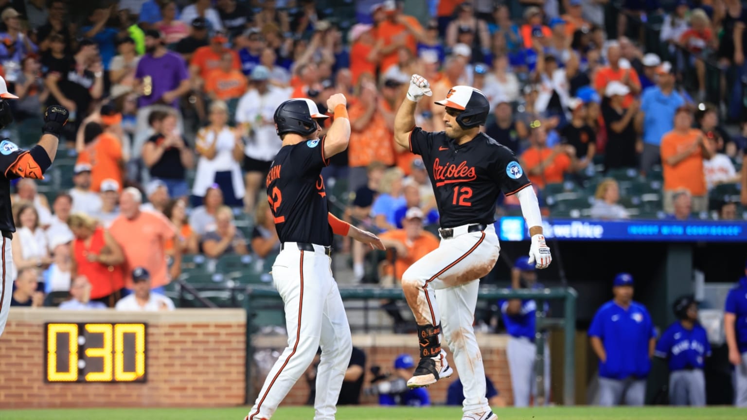 El dominicano Ramón Laureano, de los Orioles, es saludado por el coach de la tercera base luego de pegar su jonrón 15.