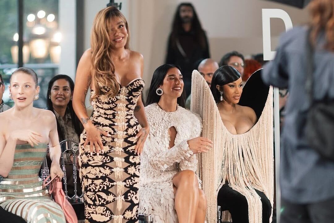 Karol G sentada junto a Dua Lipa, Schafer y Cardi B