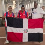 El presidente de la Federación de Atletismo, ingeniero Alexis Peguero, con la bandera dominicana en manos, junto a la atleta, Marileidy Paulino y su entrenador, Yassen Pérez, luego de la carrera final.