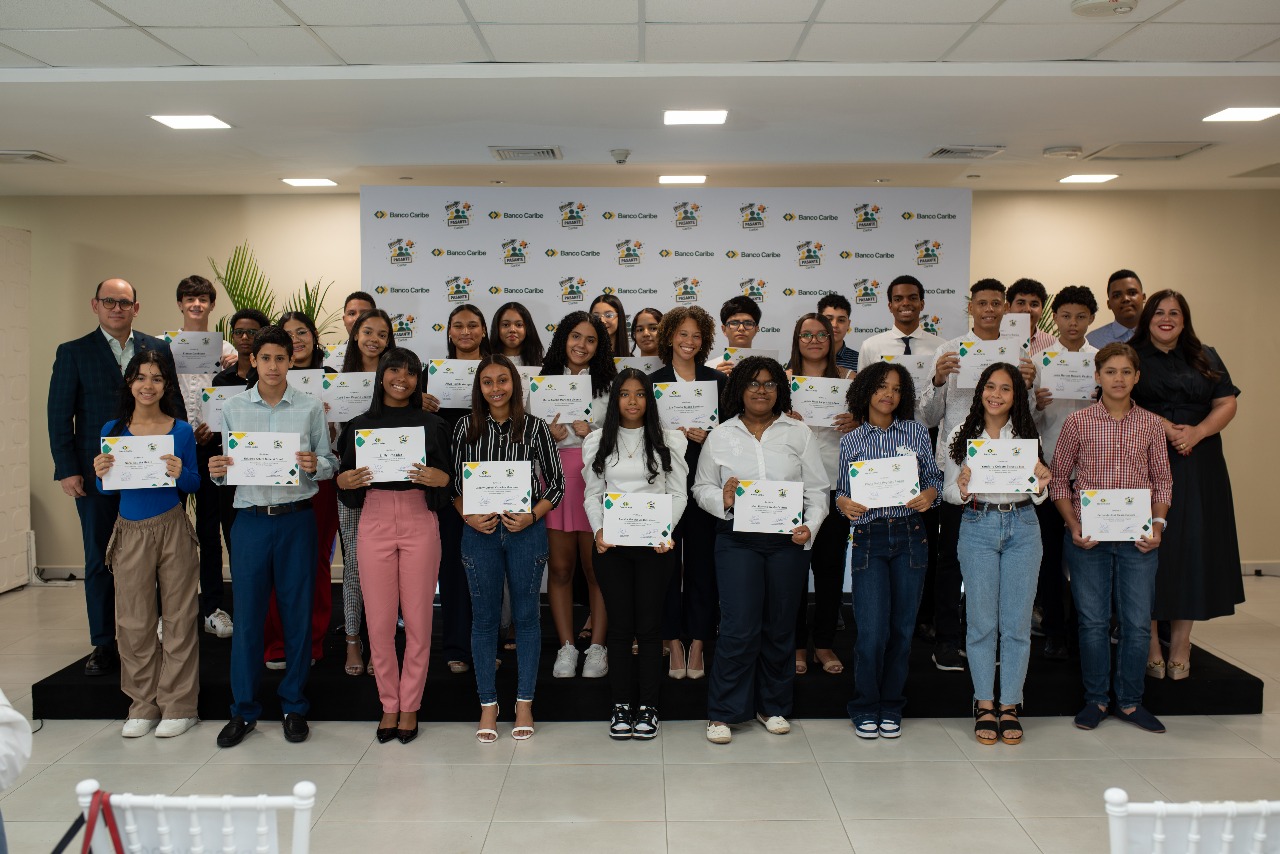 Edgar del Toro y Francesca Luna, , presidente ejecutivo y vicepresidenta de talento y cultura de Banco Caribe, respectivamente, junto a los estudiantes beneficiados.