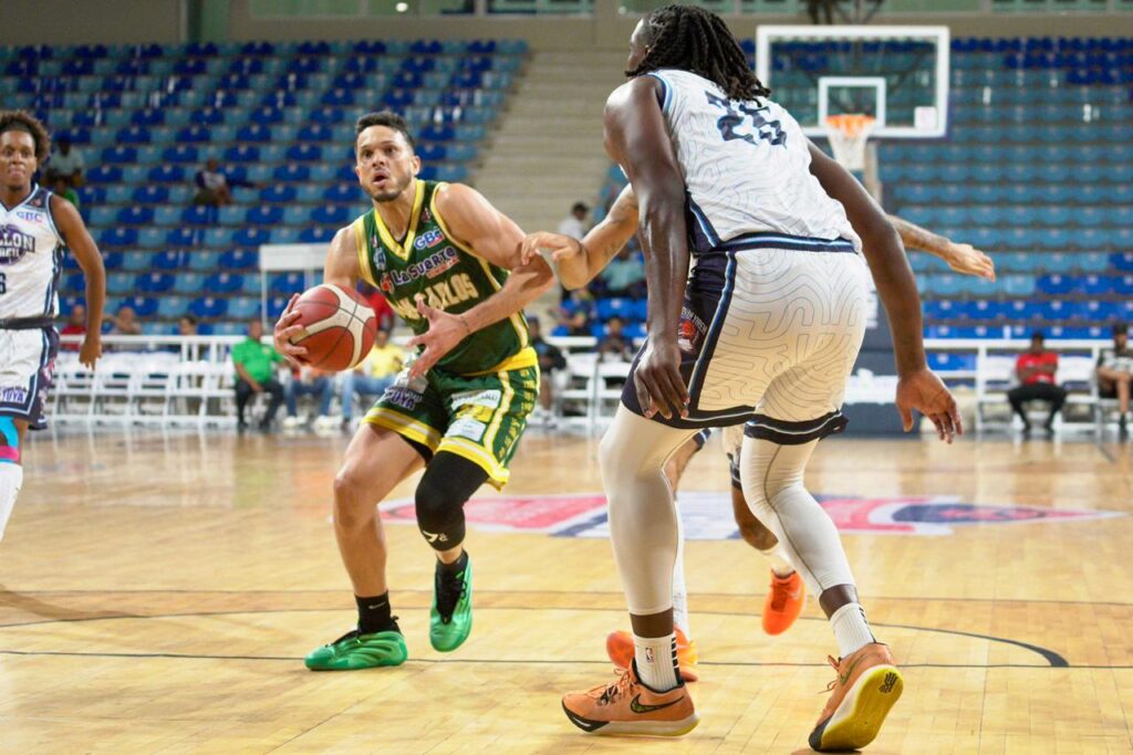 Juan Guerrero, del club San Carlos, intenta conseguir la canasta sobre la defensa de Michael Watkins, de El Millón.