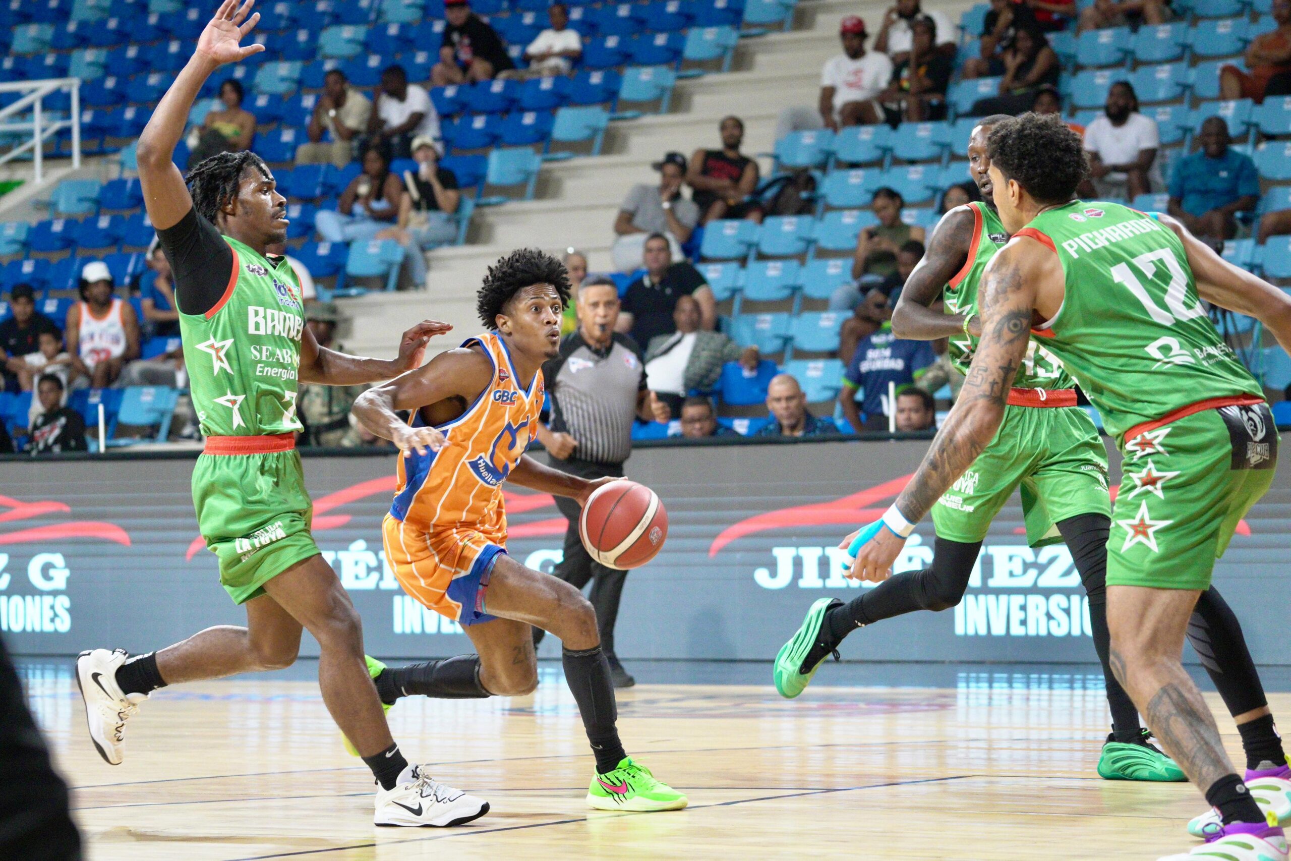 Anphernee Acevedo, de Huellas del Siglo, driblea el balón entre los jugadores bamesianos Hysier Miller y Fausto Pichardo.