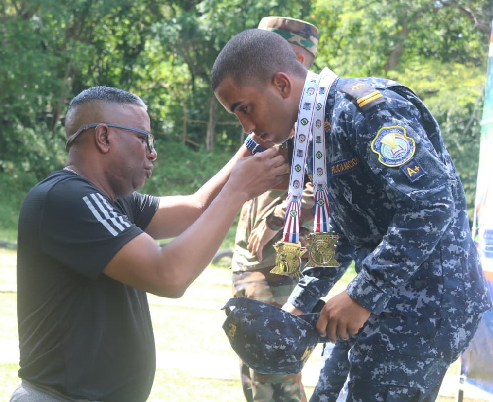 El coronel Osvaldo Montero Mena (FARD), presidente del Comité Organizador, premia al cadete de 2do. año Randy Sánchez Bautista, oro en tiro con pistola.