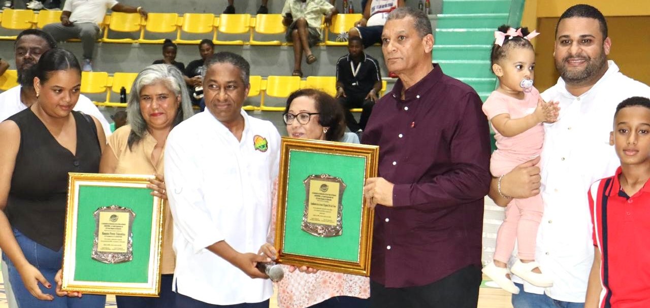 Carlos Dijol, tesorero de Abasapema, entrega la placa a la hija y viuda de Ramón Pérez Tolentino, Keomara y Kenia, y a Ambioris Tejada junto a su esposa Noris Díaz.