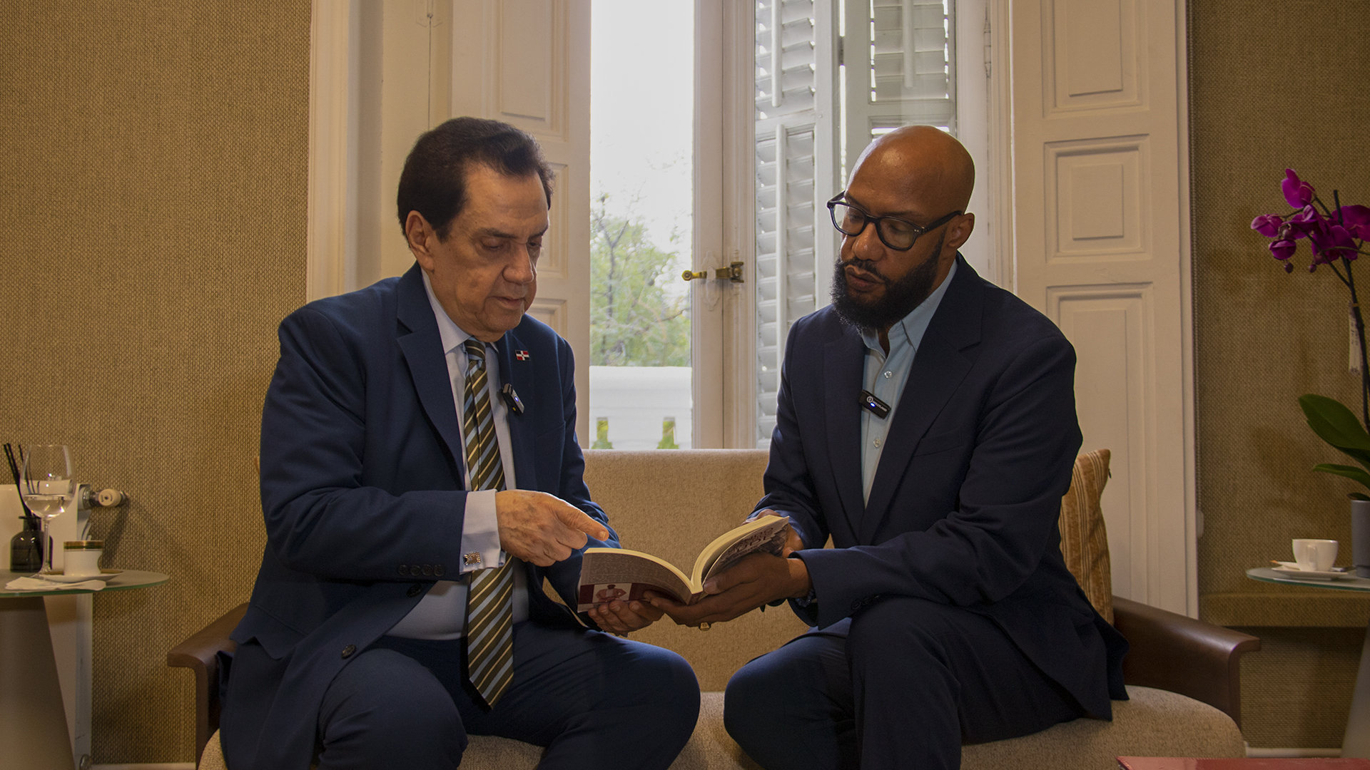 Juan Rojas comparte con el embajador Tony Raful los detalles de su obra literaria