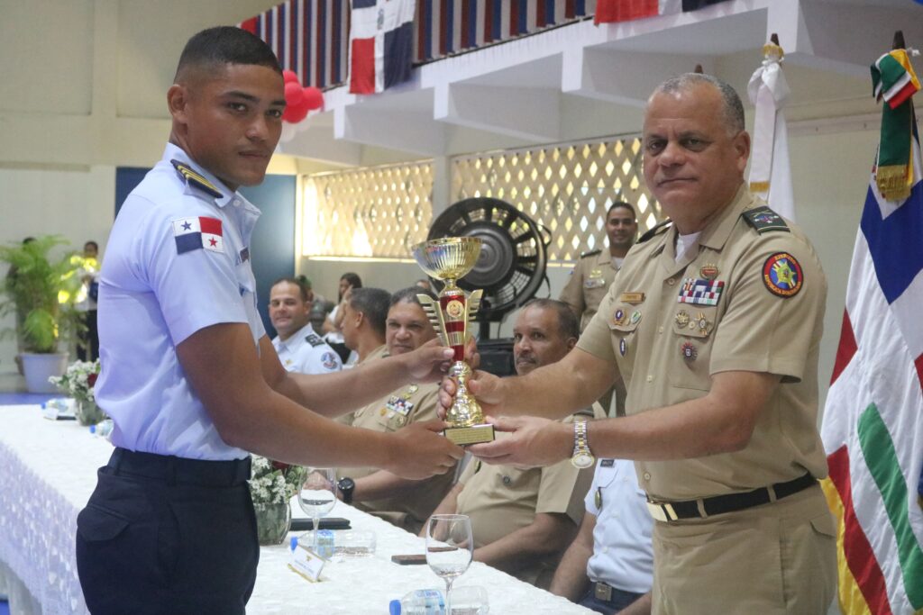 El ministro de Defensa, teniente general (ERD) Carlos Antonio Fernández Onofre, premia al cadete de tercer año Roberto Mariscal Cubilla, de la Fuerza Aérea, como el Atleta Más Destacado de los XXVIII Juegos Deportivos de Cadetes y Guardiamarinas de las Fuerzas Armadas y la Policía Nacional.