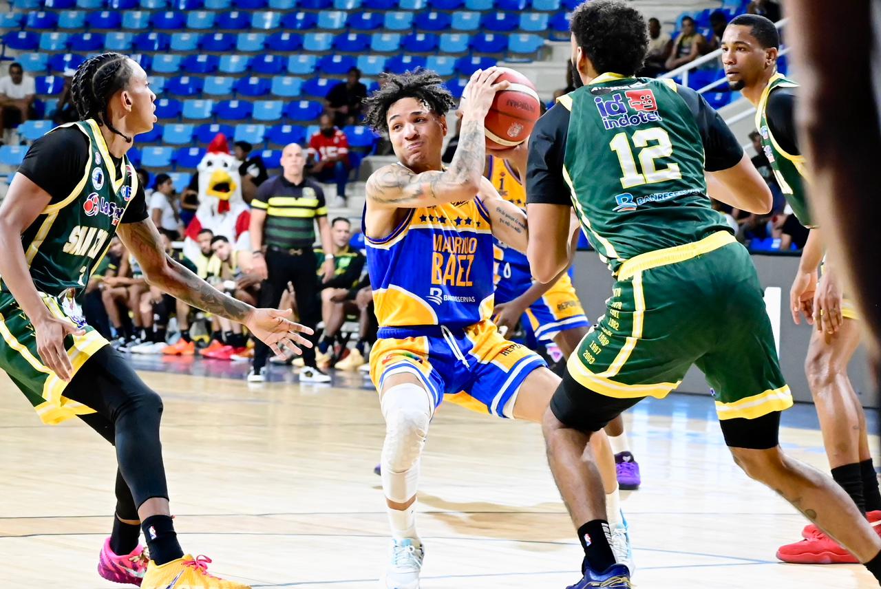 Richard Bautista, del club Mauricio Báez, es marcado por Juan Guerrero, de San Carlos.