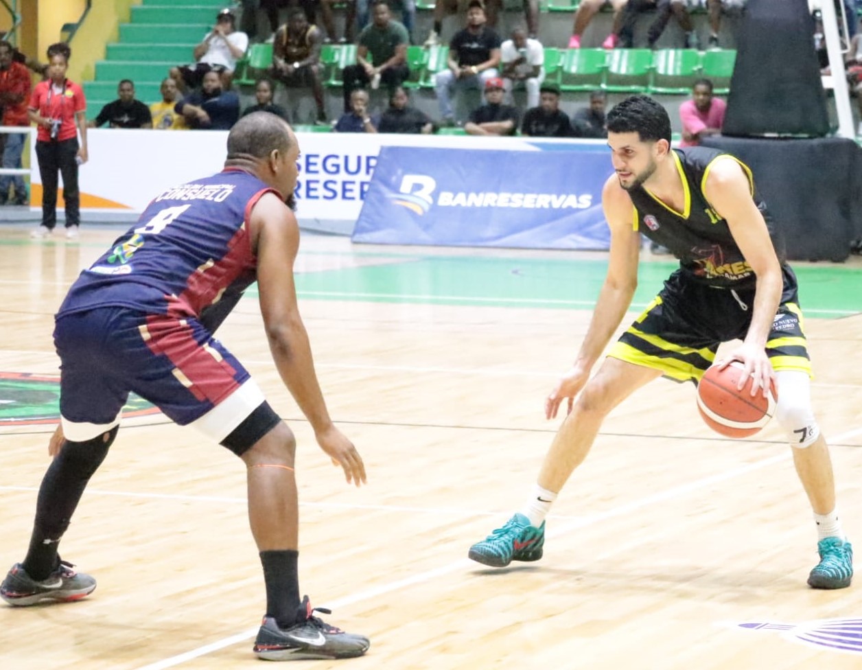 Bryan Polanco, de Titanes de Miramar, es defendido por Dresly Richardson (9), de Consuelo.