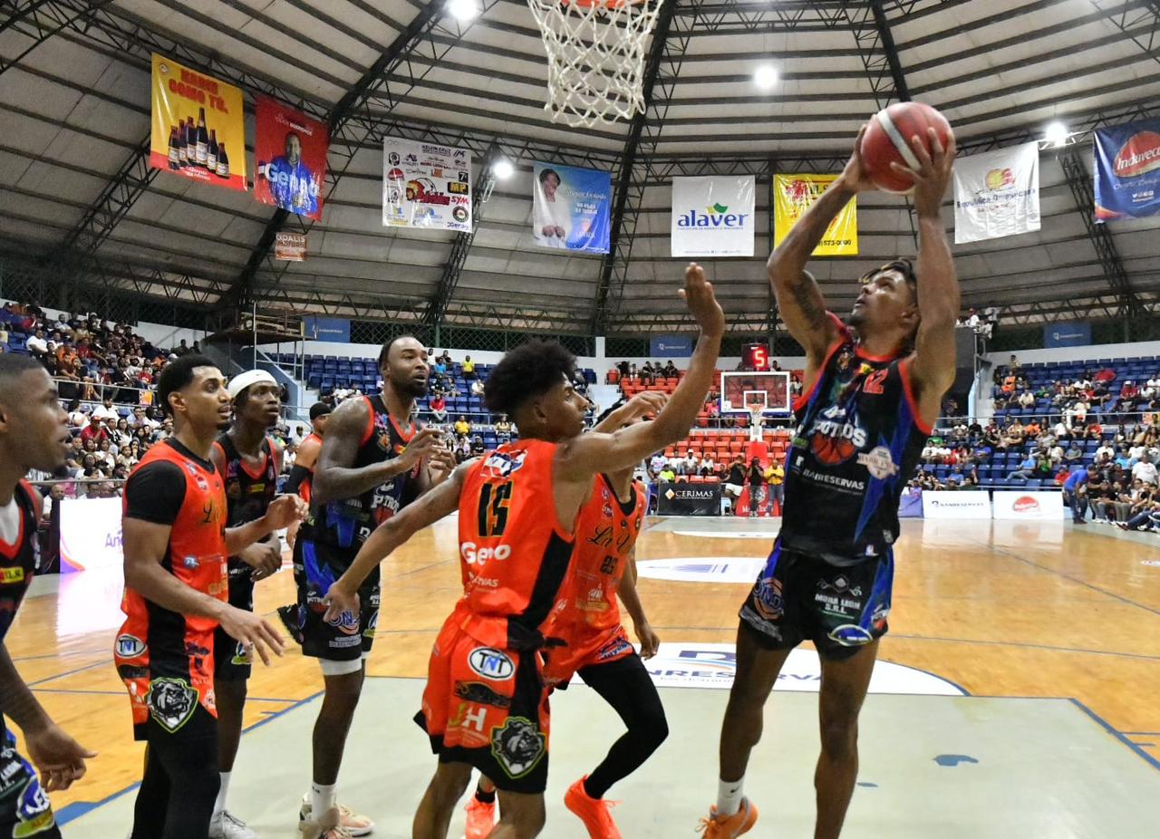 Brayan Rosado al momento de hacer un lance al aro defendido por Junior Lantigua.