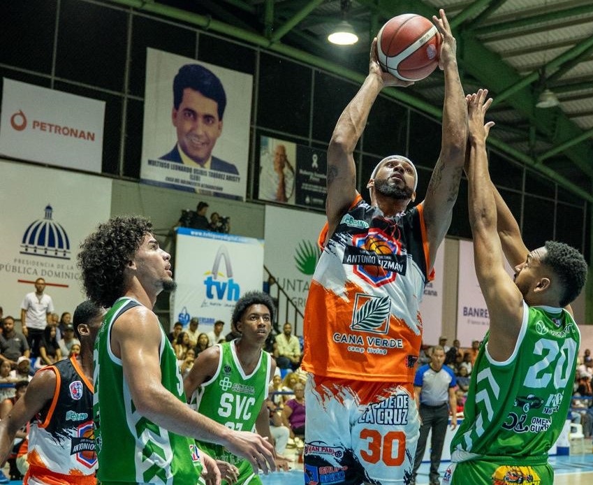 Bryan De la Cruz, del club Antonio Guzmán, en una ofensiva entre los jugadores Darwin Rosario y Manuel Duluc, de Savica.