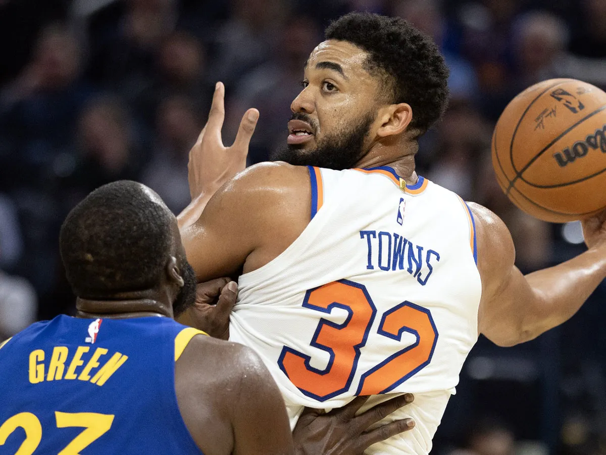 Karl Towns de los Knicks es defendido por Draymond Green.