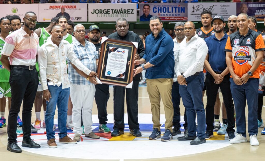 Monseñor Jesús Castro Marte recibe una placa de reconocimiento de Iván Güilamo y Jorge Tavárez, presidente de Abapa.