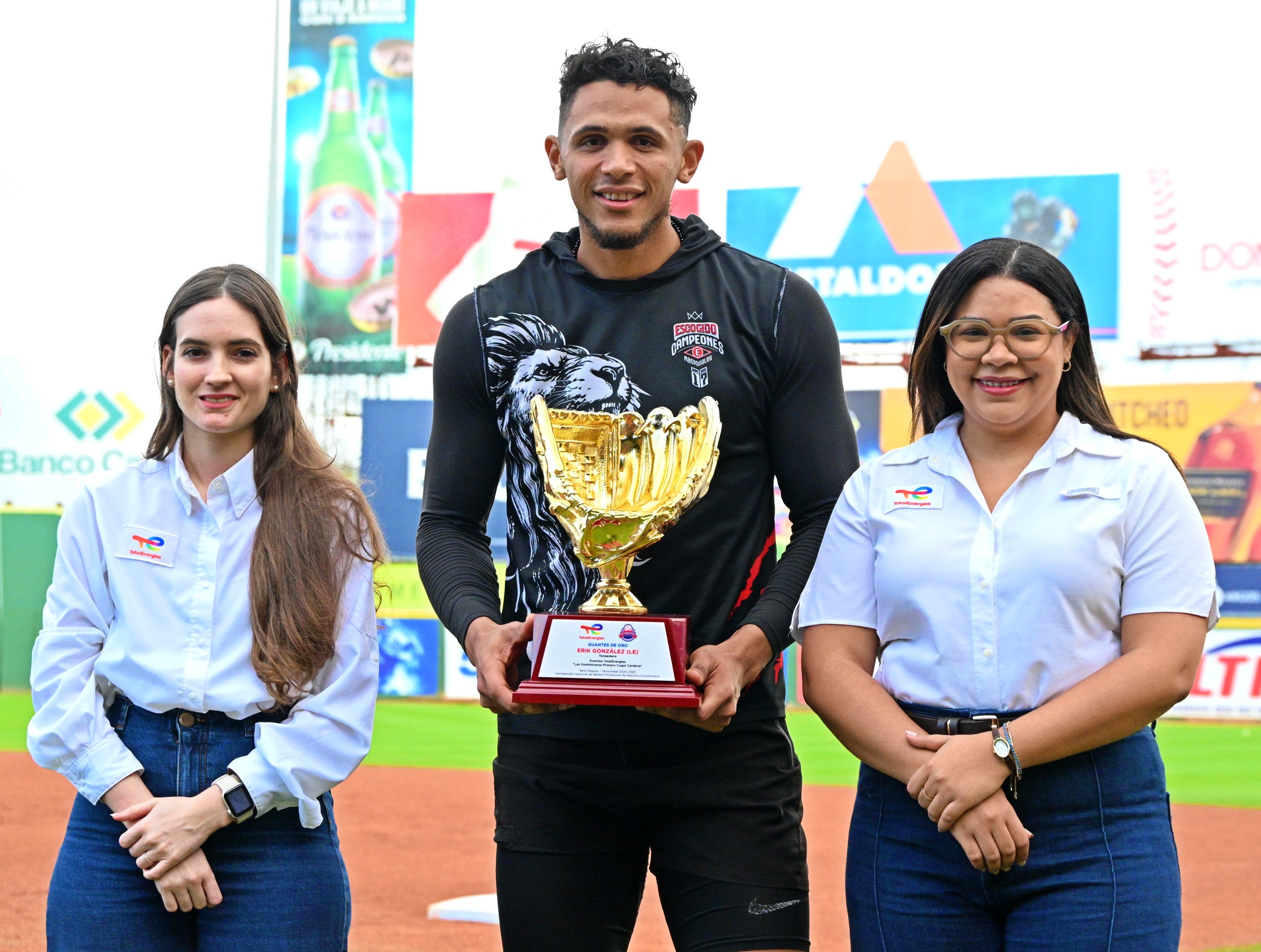 Erik González, de los Leones del Escogido, recibe su galardón como mejor defensor de las paradas cortas «Guante de Oro» de manos de las ejecutivas de TotalEnergies.