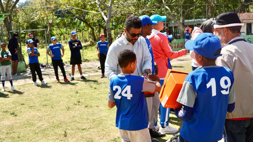 Joel Lithgow, director para América Latina de New York Yankees, entrega utilería de béisbol a niños de la liga municipal de la comunidad de Nizao - Las Auyamas, en la provincia de San José de Ocoa.