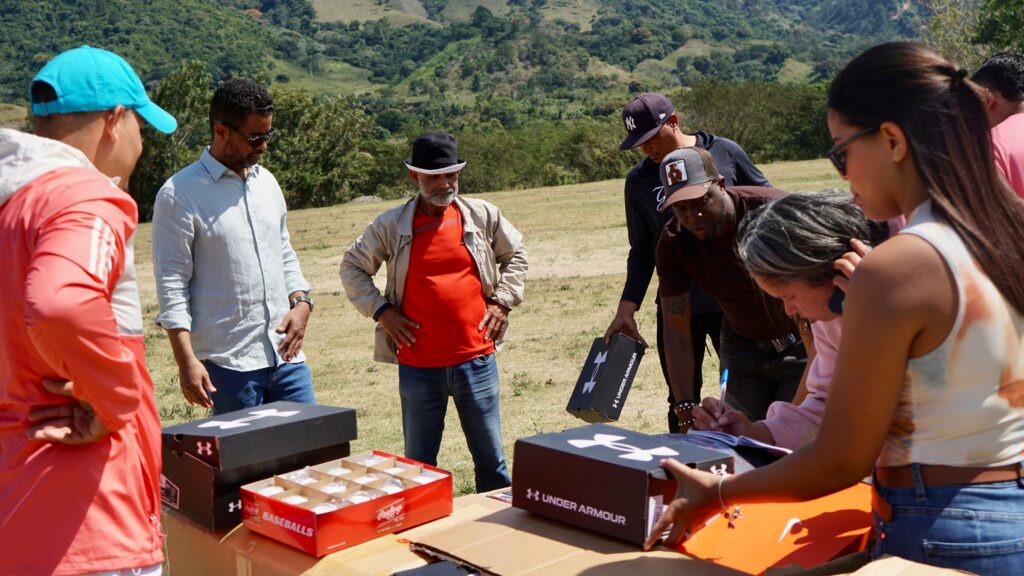 Joel Lithgow, director para América Latina de New York Yankees, entrega utilería de béisbol a niños de la liga municipal de la comunidad de Nizao - Las Auyamas, en la provincia de San José de Ocoa.