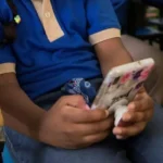 Estudiante utilizando un celular dentro de la escuela.