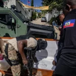 Integrante de la Policía de Haití que revisa un ataúd en busca de armas y drogas, durante un operativo contra las bandas armadas. EFE