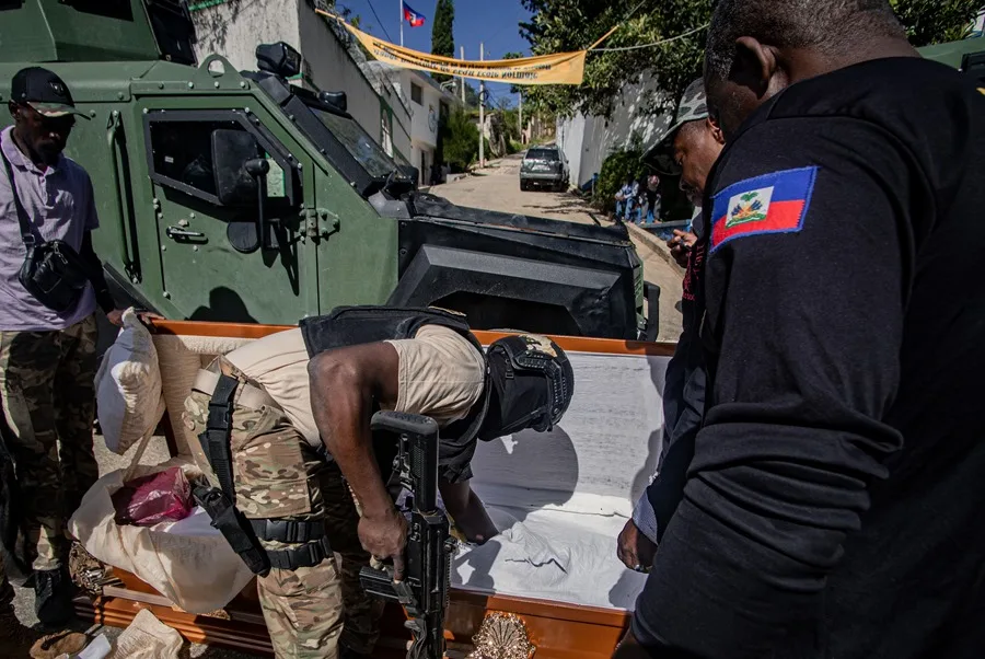 Integrante de la Policía de Haití que revisa un ataúd en busca de armas y drogas, durante un operativo contra las bandas armadas. EFE