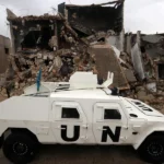 Un vehículo blindado de la Fuerza Provisional de las Naciones Unidas en el Líbano (UNIFIL) circula junto a edificios destruidos en Meiss al-Jabal, distrito de Marjayoun, sur del Líbano, en una fotografía de archivo. EFE/EPA/Wael Hamzeh.