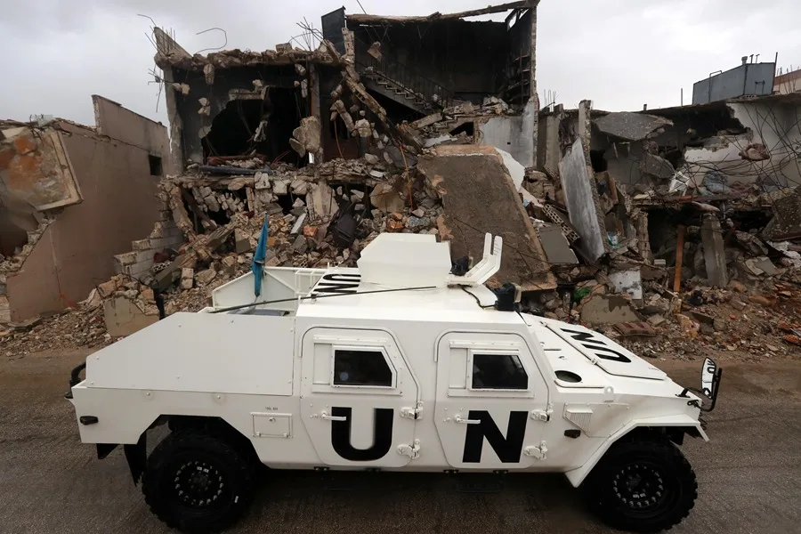 Un vehículo blindado de la Fuerza Provisional de las Naciones Unidas en el Líbano (UNIFIL) circula junto a edificios destruidos en Meiss al-Jabal, distrito de Marjayoun, sur del Líbano, en una fotografía de archivo. EFE/EPA/Wael Hamzeh.