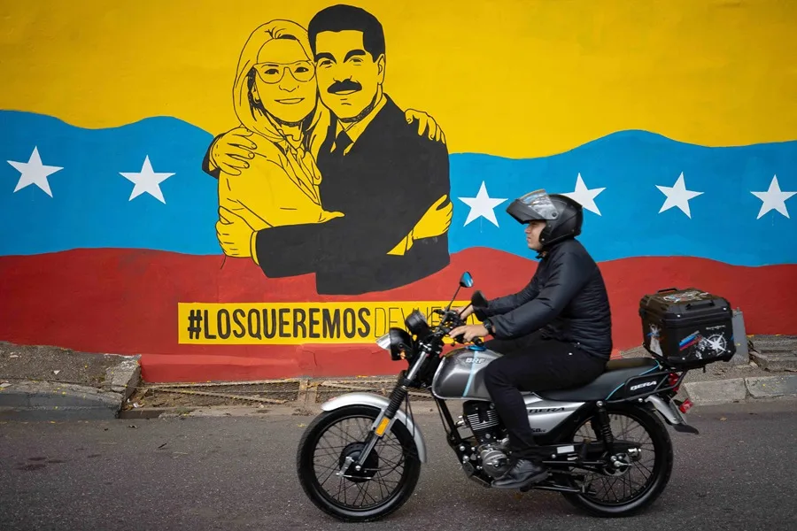 Una persona transita frente a un mural del presidente de Venezuela, Nicolás Maduro, y su esposa, Cilia Flores, este lunes, en Caracas (Venezuela). EFE