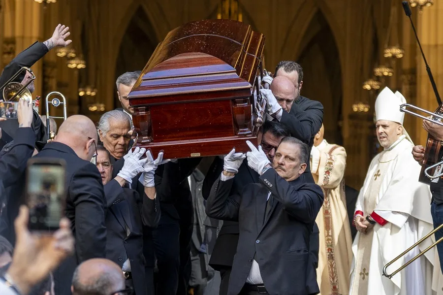 Personas sostienen el féretro del cantante Willie Colón en Nueva York
