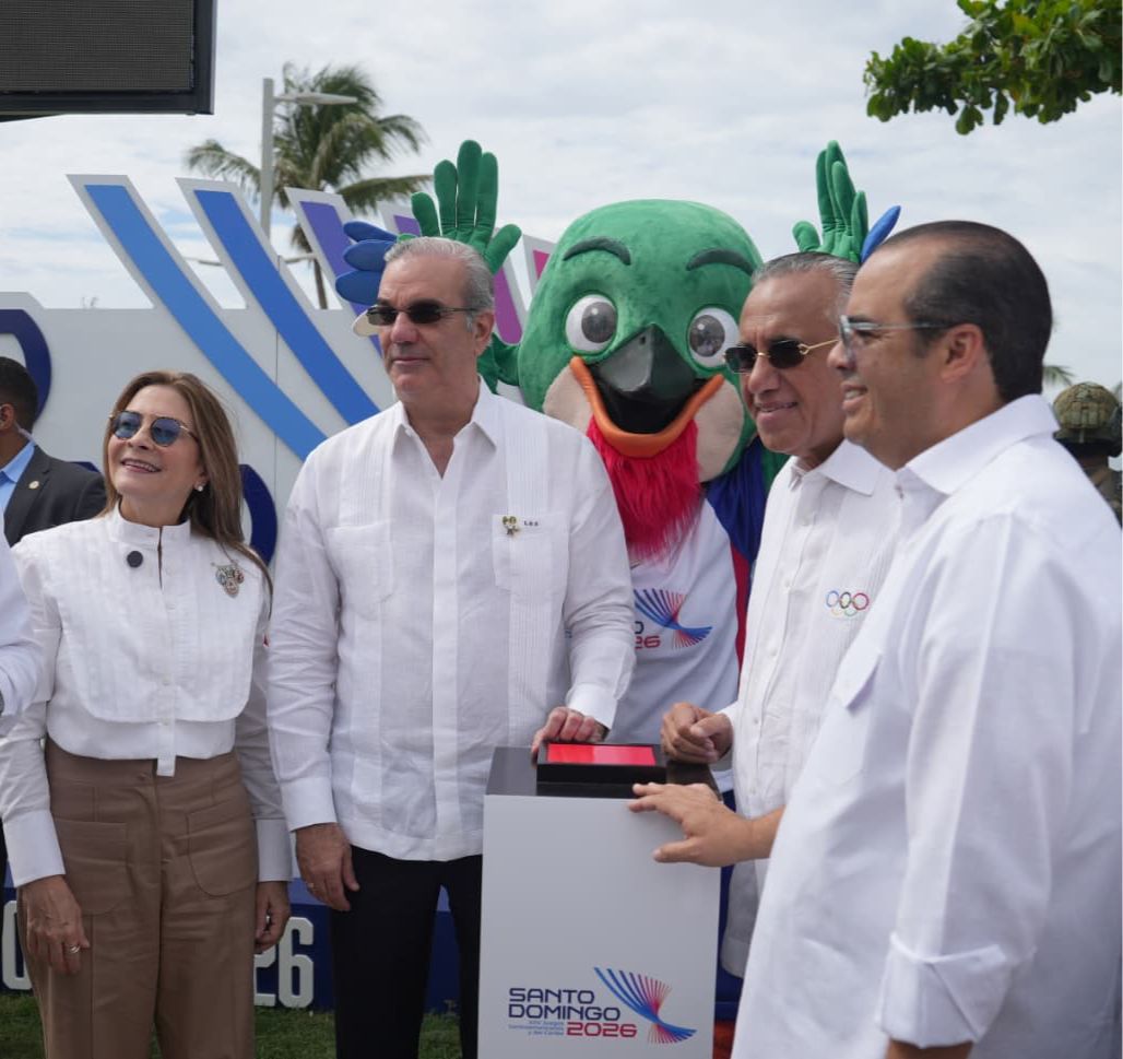 El presidente Luis Abinader activa el reloj oficial de cuenta regresiva hacia los XXV Juegos Centroamericano y del Caribe Santo Domingo 2026.Le acompañan, desde la izquierda, la alcaldesa Carolina Mejía, la mascota Colí, Luisín Mejía y José Luis Montero