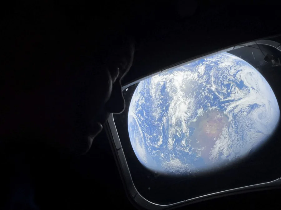 El comandante Reid Wiseman observa la Tierra mientras continúan adentrándose en el espacio hacia la Luna. EFE/ NASA.