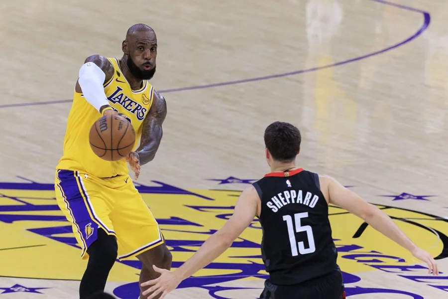 LeBron James (i) de Los Angeles Lakers pasa un balón este sábado, durante el primer partido de la serie de eliminatorias de la NBA entre Houston Rockets y Los Angeles Lakers en el Crypto.com Arena de Los Ángeles, California (Estados Unidos). EFE/Ariana Ruiz.