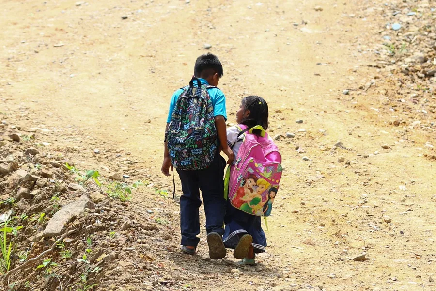 Fotografía del 8 de abril de 2026 que muestra a dos estudiantes caminando en quebrada Sardina en la comunidad comarcal (Panamá). EFE/ Carlos Lemos.