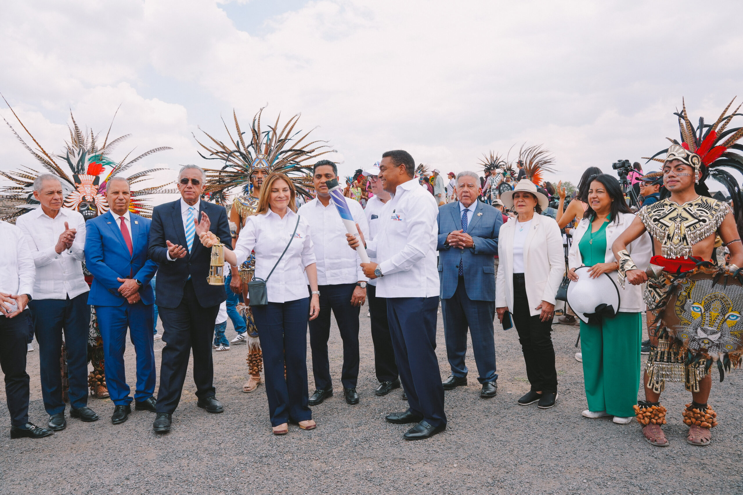 La alcaldesa de Santo Domingo, Carolina Mejía, asume la custodia de la llama centroamericana., mientras José P. Monegro, presidente del Comité Organizador, sostiene la antorcha. Les acompañan, desde la izquierda, Fernando Langa, Garibaldy Bautista, presidente del COD, el ministro de Deportes, Kelvin Cruz; Felipe Vicini y el embajador dominicano en México, Juan Bolívar Díaz, entre otros.