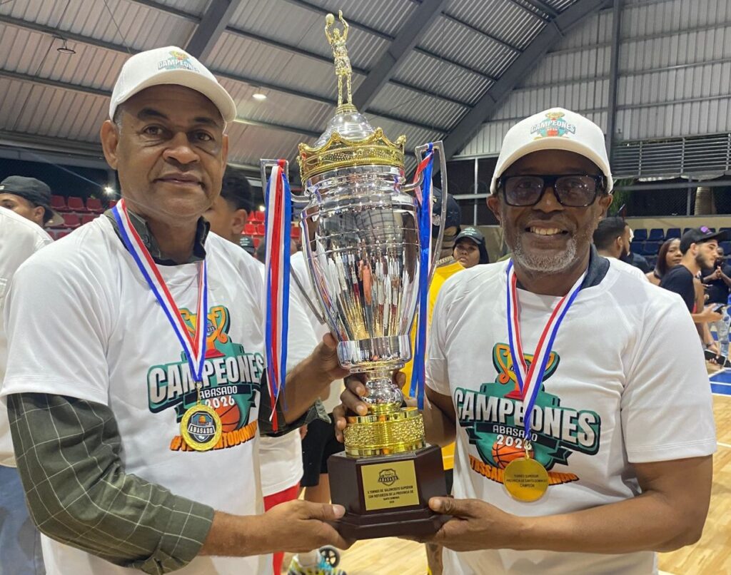 Víctor Hansen y Ronny Jáquez, presidente y secretario general del club Los Mina, sostienen la Copa Seaboard que conquistaron ante los Trenes.