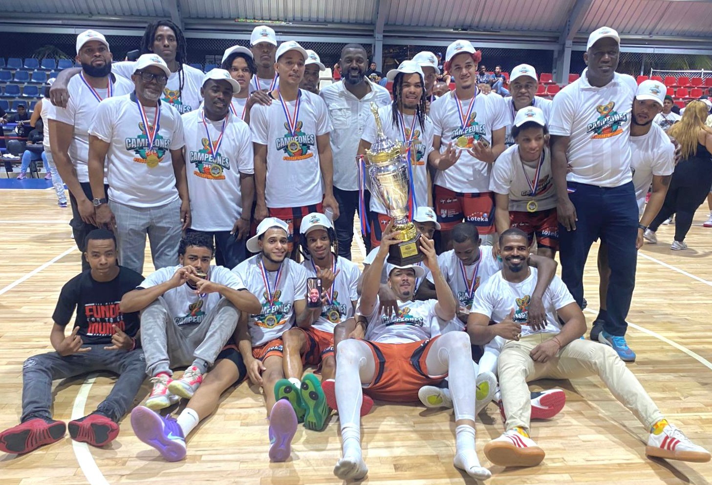 William Cabral Lugo (Nemeneme), presidente de Abasado, entregó la Copa a Joni Liriano (en suelo), junto a sus compañeros de Los Mina.