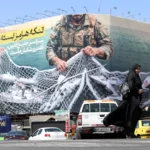 Una mujer pasa junto a una valla con el mensaje "El estrecho de Ormuz permanecerá cerrado" en la plaza Enghelb de Teherán. EFE/Abedin Taherkenareh.