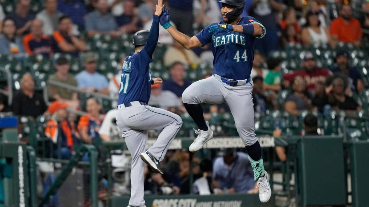 Julio Rodríguez celebra su jonrón 7 con el coach de tercera base el también dominicano Manny Acta.